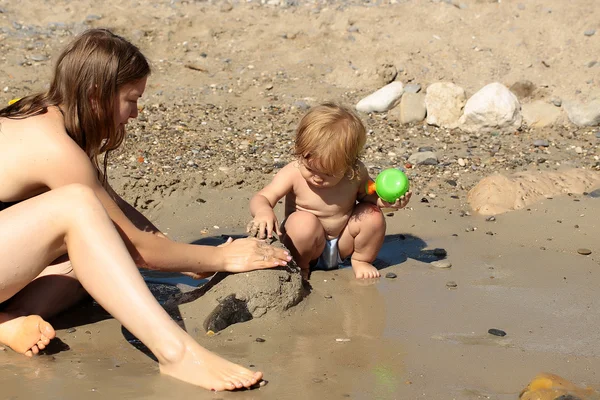 Madre jugando con chico en la arena — Foto de Stock