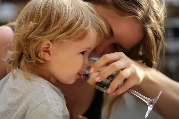 Chłopiec wody pitnej z matka — Zdjęcie stockowe