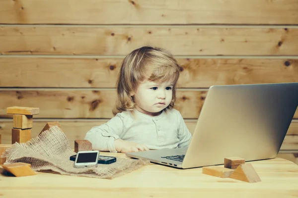 Menino pequeno com computador e telefone — Fotografia de Stock