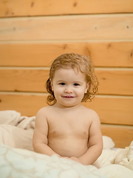 Jongen zit op handdoek — Stockfoto