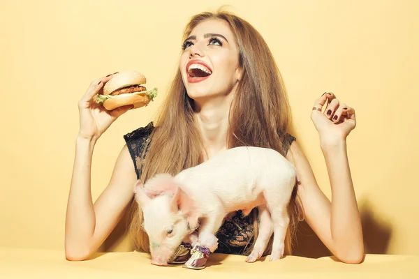 Meisje eten hamburger met varken — Stockfoto