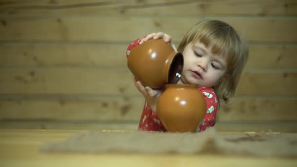 Rozkošné dítě nalévá vodu ze džbánu do džbánu — Stock video