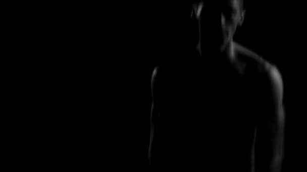 Sexy naked guy with a nice athletic body dancing on a black background in the dark — Stock Video