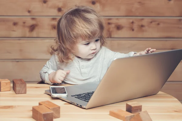 Маленький хлопчик з комп'ютером і телефоном — стокове фото