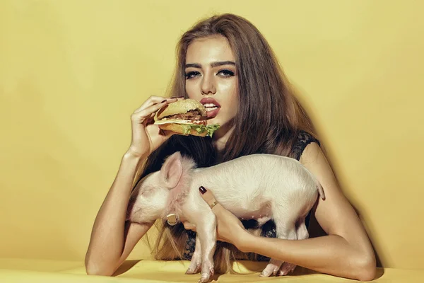 Woman with burger and pigglet — Stock Photo, Image