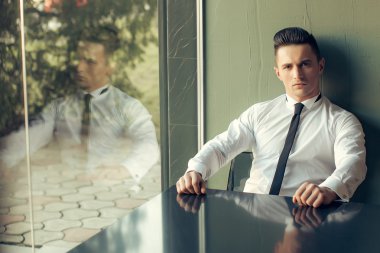 Man modeli masada oturur