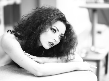 Masanın üzerinde yatan muhteşem genç kadın 