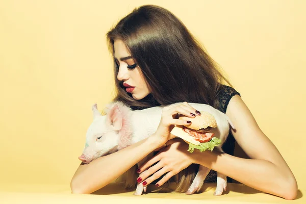 Woman with burger and pigglet — Stock Photo, Image