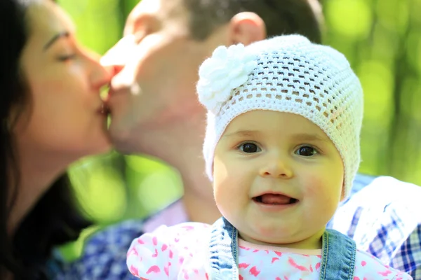 Girl and kissing parents — Stock Photo, Image