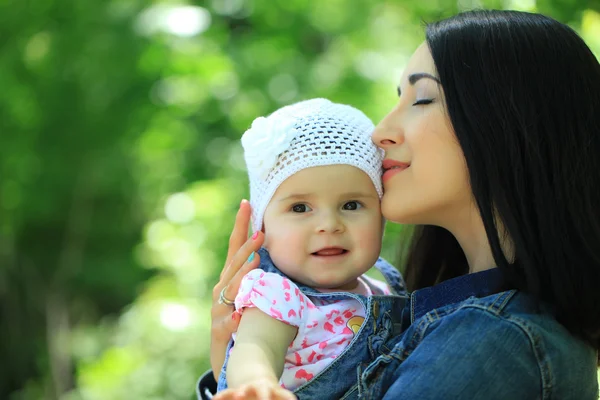 Mother kissing and holding daughter — Stock Photo, Image