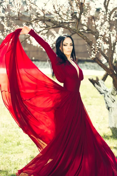 Mulher em vestido vermelho perto de flor — Fotografia de Stock