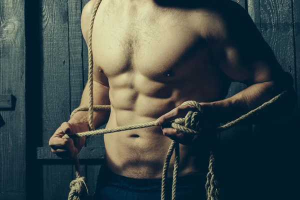 Homem muscular segurando corda — Fotografia de Stock