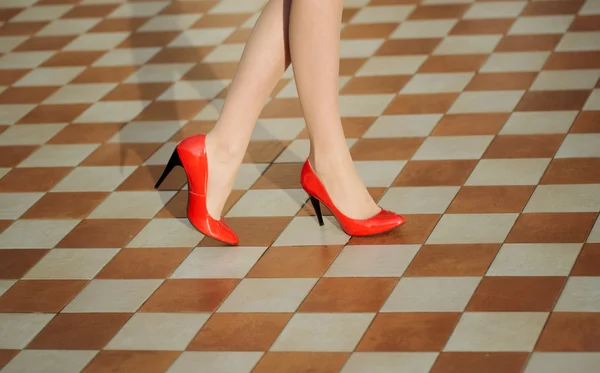 Pernas femininas em sapatos vermelhos — Fotografia de Stock