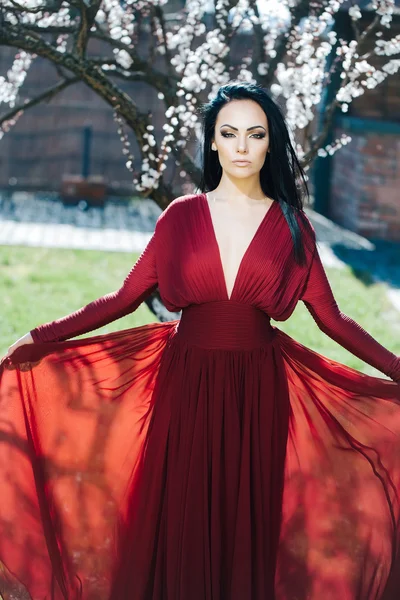 Menina em vestido vermelho perto de flor — Fotografia de Stock