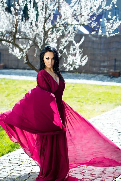 Menina em vestido vermelho perto de flor — Fotografia de Stock