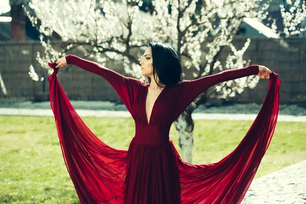 Femme en robe rouge près de fleur — Photo