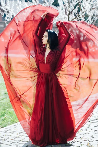 Menina em vestido vermelho perto de flor — Fotografia de Stock