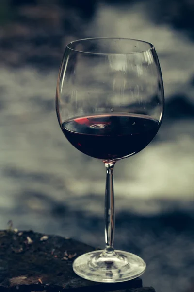 Red wine glass near water — Stock Photo, Image