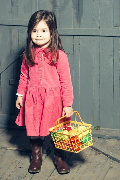 Menina com comida de plástico na cesta — Fotografia de Stock