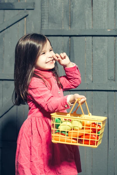 Девушка с пластиковой пищей в корзине — стоковое фото