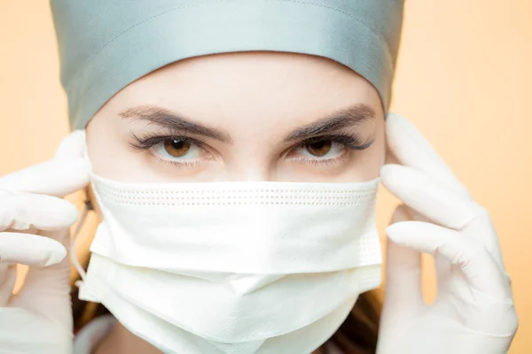 Young woman doctor in cap and face mask — Stock Photo, Image