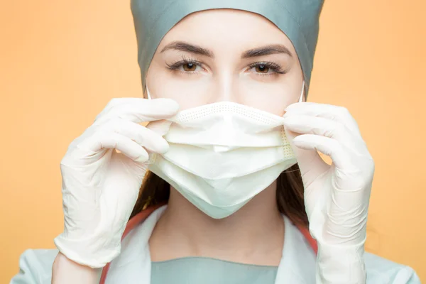 Young woman doctor in cap and face mask — Stock Photo, Image