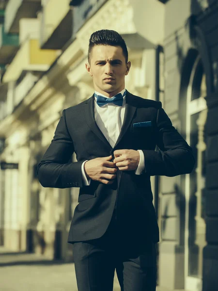 Schöner Mann knöpft Anzugmantel auf — Stockfoto