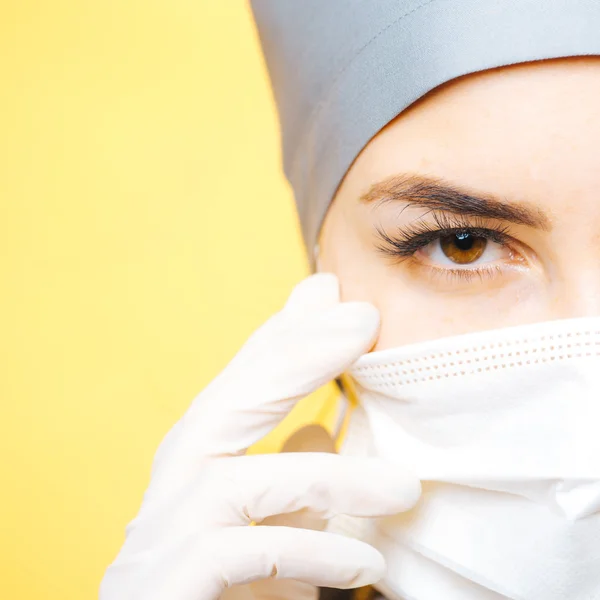 Young woman doctor in cap and face mask — Stock Photo, Image