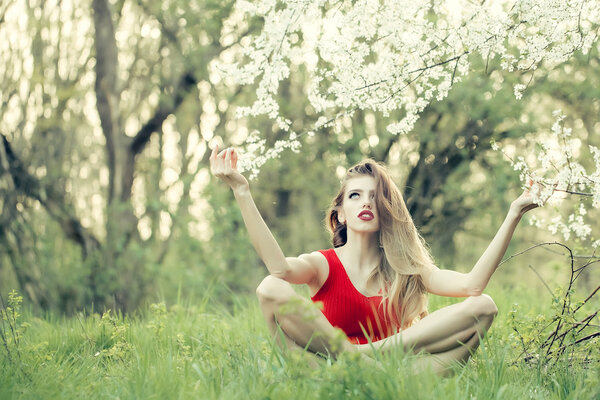 Beautiful young woman enjoying beauty in a flowering spring garden