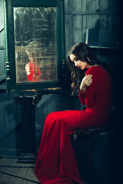 Mulher em vestido vermelho perto do espelho — Fotografia de Stock