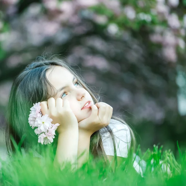 Kleines Mädchen auf blühendem Gras — Stockfoto