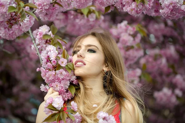 Mooie jonge vrouw in bloeiende boomgaard — Stockfoto