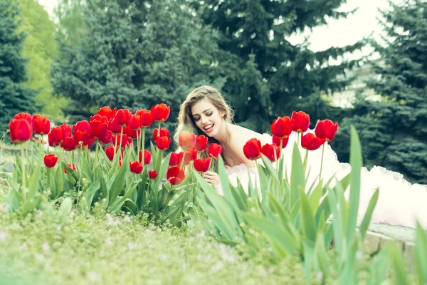 Smiling girl with red tulips — Stock Photo, Image