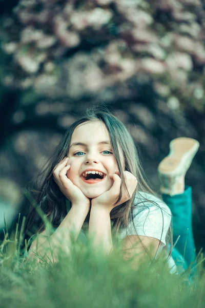 Kleines Mädchen auf blühendem Gras — Stockfoto