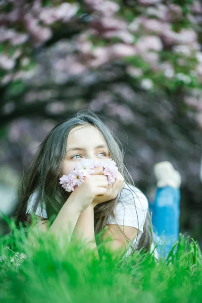 Çiçek çimenlerin üzerinde küçük kız — Stok fotoğraf