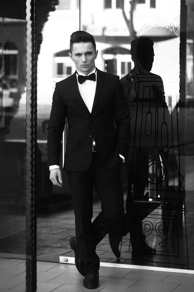 Young man in suit near glass door — Stock Photo, Image