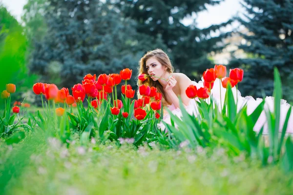 Lachende meisje met rode tulpen — Stockfoto