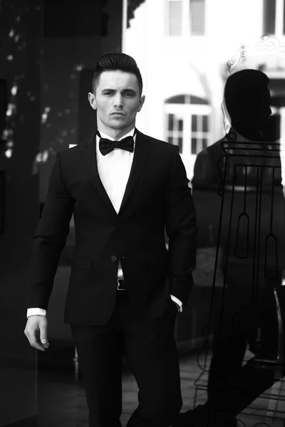 Young man in suit near glass door — Stock Photo, Image