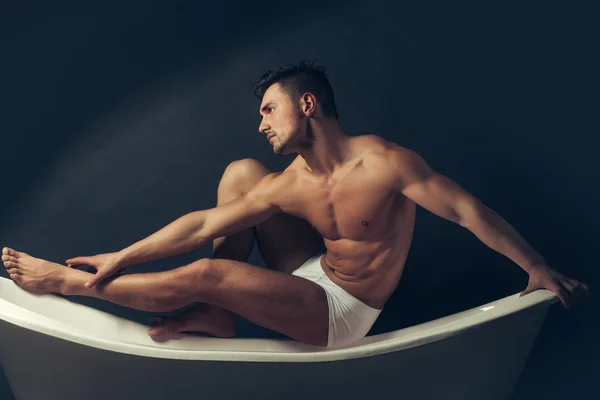 Homme musclé sur la baignoire — Photo