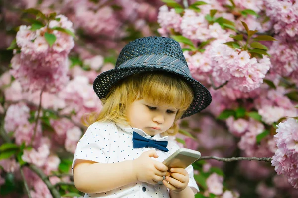 Retro boy with phone in blossom — Stock Photo, Image