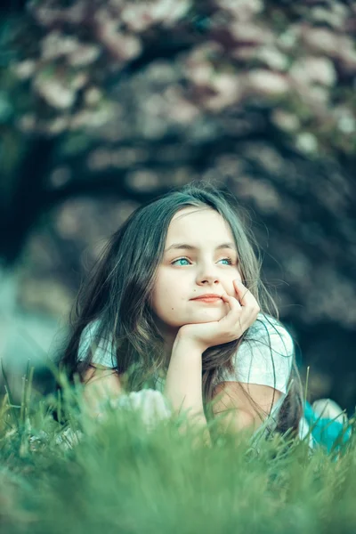 Kleines Mädchen auf blühendem Gras — Stockfoto