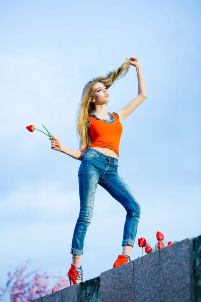 Mignon jeune fille tient la tulipe rouge — Photo