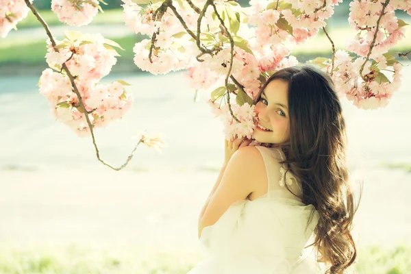 Pequeña chica sonriente en flor — Foto de Stock