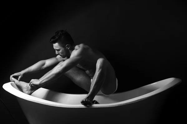 Muscular man on bathtub — Stock Photo, Image