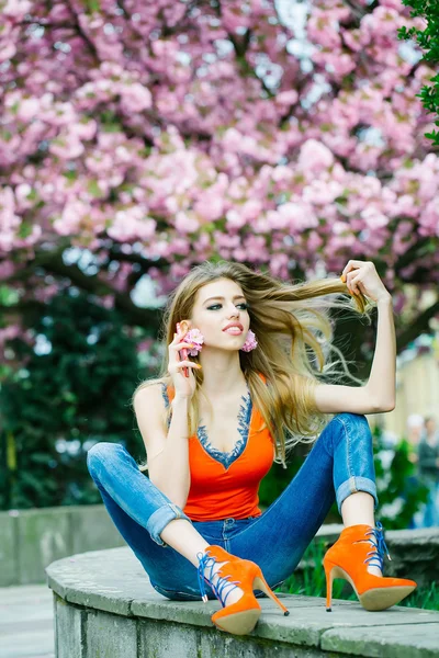 Chica sentada en un parque con teléfono —  Fotos de Stock