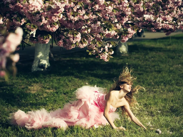 Sinnliche Frau auf Gras mit Blüte — Stockfoto