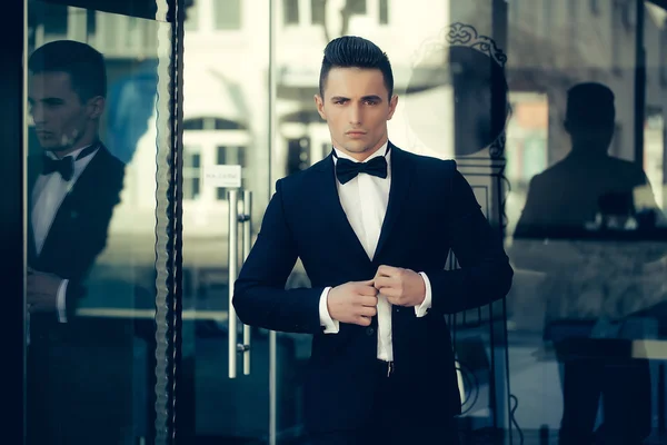 Young man in suit near glass door — Stock Photo, Image