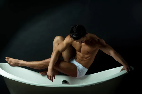 Homme musclé sur la baignoire — Photo