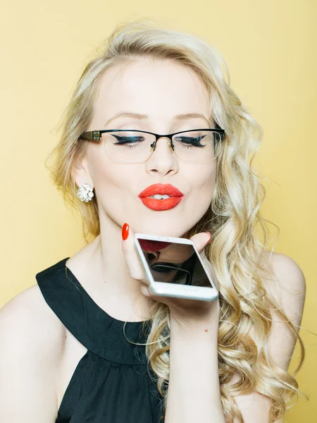 Sexy blonde in glazen met telefoon — Stockfoto