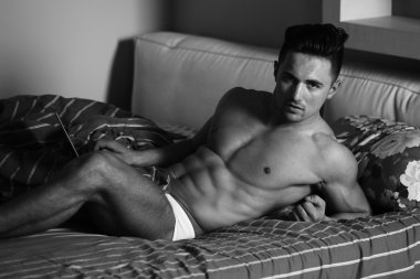 Yatakta kaslı seksi adam